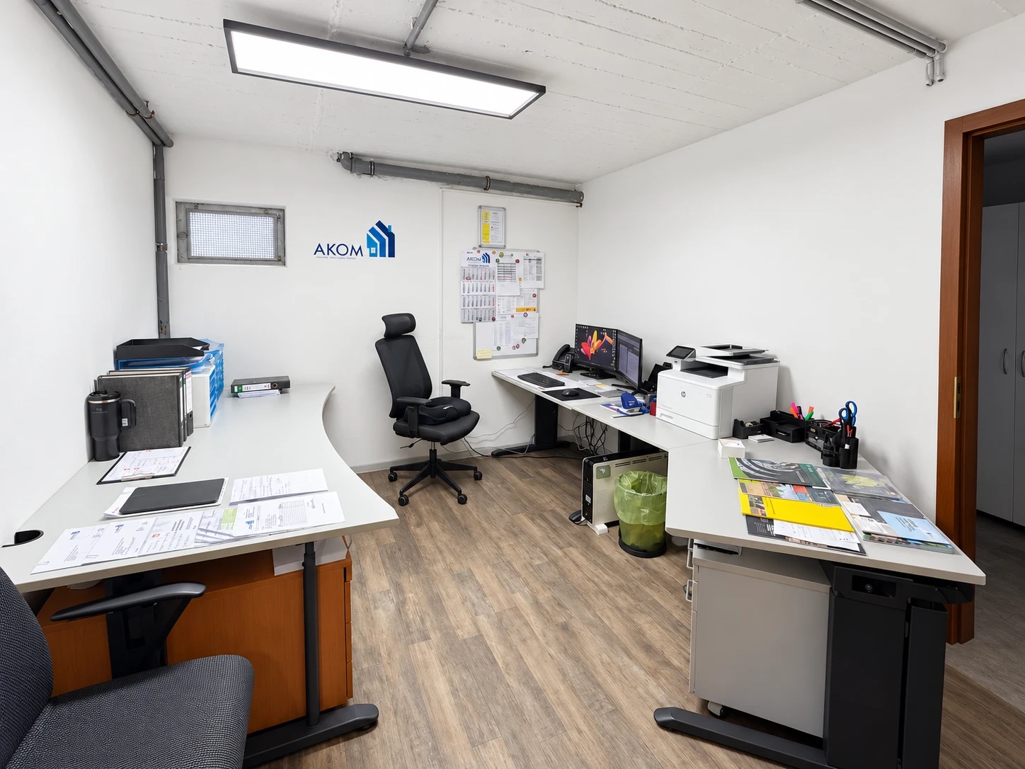 Büro im AKOM-Firmensitz mit zwei Arbeitsplätzen und AKOM-Logo