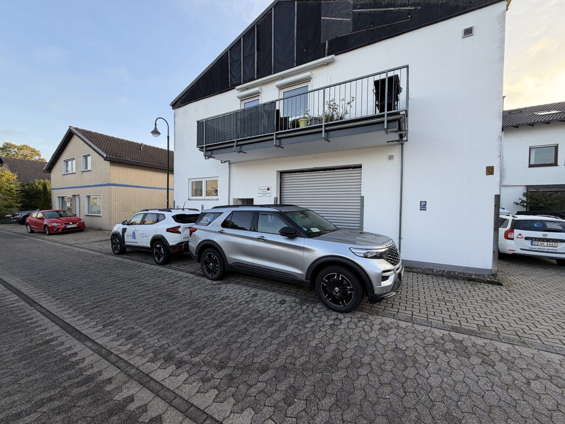 AKOM-Servicefahrzeuge vor dem Bürogebäude der AKOM Facility Services GmbH